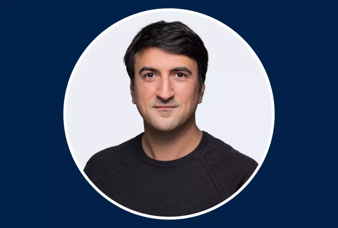 Heashot of man with black hair and black tshirt